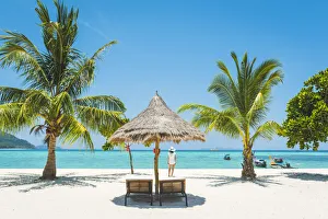 Beach Prints: Ko Lipe, Satun Province, Thailand. Tourist admiring the view on a white sand beach (MR)