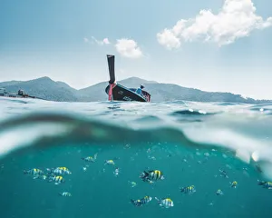 Ko Lipe, Satun Province, Thailand. Split image of long tail boat and colorful fishes