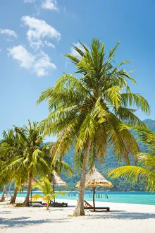 Ko Lipe, Satun Province, Thailand. Sunbeds with nipa umbrella on the beach
