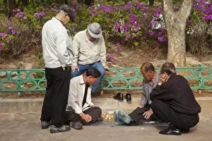 Korea, Seoul, Men playing board game in park outside Jongmyo Shrine