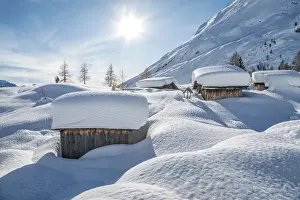 landscape of snow-covered mountain huts in the locality Ciamp de Lobia, Fedaia pass