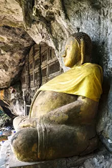 Images Dated 24th June 2014: Laos, Luang Prabang. Buddha statue at the entrance of Pak Ou Caves on the Mekong river