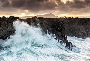 Storm Prints: Large waves breaking on the volcanic coastline at dawn