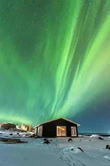 Laugarvatn, Iceland. Northern lights over typical Icelandic houses in winter