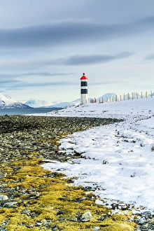 Mountain Peak Prints: Lighthouse on a beach covered with snow, Tromso, Norway