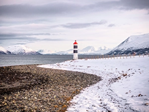 Mountain Peak Prints: Lighthouse on a beach covered with snow, Tromso, Norway