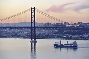 Lisbon and 25 de Abril bridge over the Tagus river, at dusk. Portugal