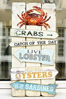 Sign Gallery: List of fresh seafood on sale in a traditional harbour shop, Teignmouth, Devon, UK