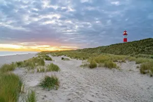 Alemboog Prints: List-Ost lighthouse among grass covered sand dunes at sunrise