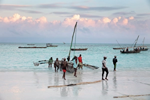 Zanzibar Prints: Local fishermen carrying their dhow up the beach, Nungwi, Zanzibar, Tanzania