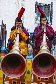 Local monks with ceremonial dress playing tibetan horns during a festival, Lo Manthang