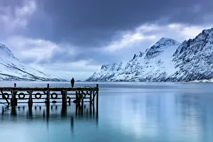 Jetty Prints: Lone figure standing on a jetty at dusk