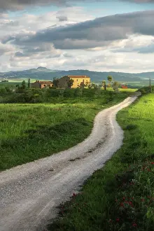 Rolling Hills Prints: A lonely countryhouse on a cloudy spring afternoon gets illuminated by the evening sun in Val d'Orcia