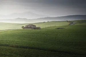 Rolling Hills Prints: A lonely countryhouse gets the first light of the day as the storm was fading in Val d'Orcia