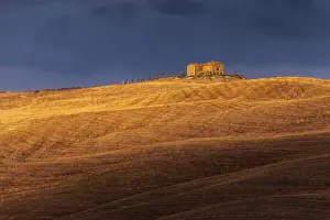 Countryhouse Prints: A lonely countryhouse and some rolling hills illuminated by the warm sunset light in autumn