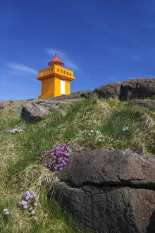 Light Houses Collection: Low angle view of lighthouse on cliff at Djupivogur, East Iceland, Iceland