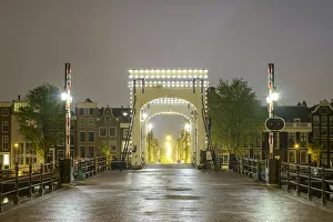 Rainy Prints: Magere Brug illuminated at night on foggy evening, Amsterdam, North Holland, Netherlands