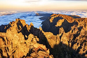 Above The Clouds Collection: Majestic mountains of Pico das Torres and Pico do Arieiro lit by sunset, aerial view