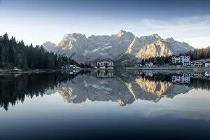 The majestic Sorapiss mountain and the small village of Misurina perfectly reflecting in the Misurina lake duirng a