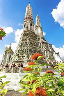 Clear Sky Prints: Majestic stupa tower of Wat Arun Buddhist temple framed by colorful flowers