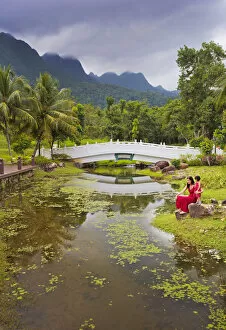 Malaysia, Langkawi, Oriental Gardens, Woman and girl sitting by lake MR