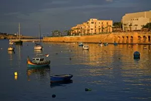 Images Dated 8th October 2008: Malta, Europe; Colourful traditional wooden boats in the placid bay of the former fishing village