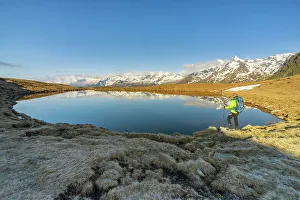 Trekker Prints: Man at Andossi Lake over Splugenpass at sunrise, Sondrio, Grigioni, Lombardy, Italy (MR)