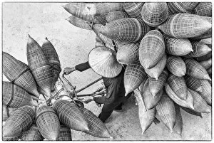 Black and White Gallery: A man on the bicycle loaded with the conical bamboo fish traps, near Hanoi, Vietnam