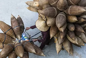 Images Dated 16th April 2019: A man on the bicycle loaded with the conical bamboo fish traps, near Hanoi, Vietnam