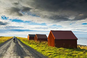 Cycle Gallery: Man on Bike & Red Fishing Huts, Eggum, Lofoten Islands, Norway