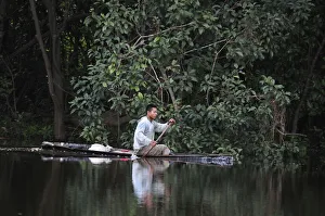 Man in a dugout canoe on the Amazon River, near Puerto Narino, Colombia