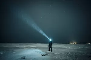 Images Dated 25th May 2022: Man exploring the sky at night on a iced lake on the arctic circle, Abisko, Sweden