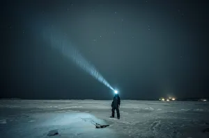 Man exploring the sky at night on a iced lake on the arctic circle, Abisko, Sweden Man exploring the sky at night on a iced lake on the arctic circle, Abisko, Sweden