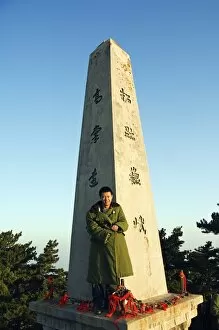 Sight Seeing Gallery: A man in green army jacket on a monument on the top of Mount Hua