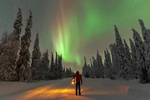 Rime Ice Prints: Man with lantern standing in the middle of an icy road looking at Northern Lights (Aurora Borealis)