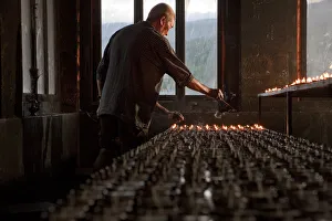A man lighting candles in a temple in Bhutan