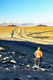 Catamarca Prints: Man looking at a desert road, El Penon, Puna, Catamarca, Argentina. (MR)