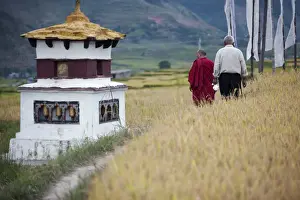 Wangdue Prints: A man and a monk walk past a chorten on the way to the fertility temple in Wangdue