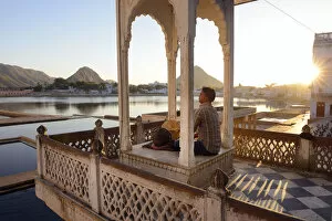 Man playing the drums overlooking the Holy Baths, Pushkarr, Rajasthan, India