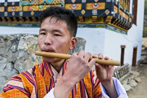 Bhutan Prints: A man playing the flute at a local festival in Paro District, Bhutan