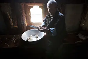 Liquor Prints: A man preparing potatos in the manufacture of arra in Ura in the Bumthang, Valley