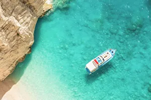 Zakynthos Prints: A man relaxing on his yacht docked at Navagio beach, Zakynthos, Ionian Islands, Greece