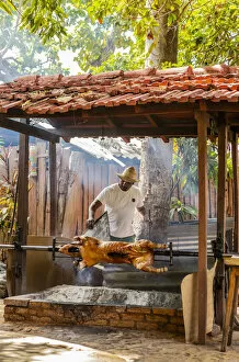 Images Dated 29th May 2020: A man roasting a pig in a restaurant in Trinidad, Sancti Spiritus, Cuba