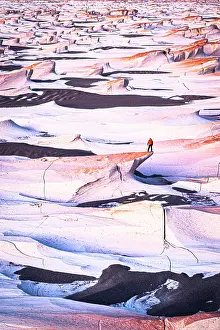 Catamarca Prints: Man standing on colorful volcanic rocks at sunrise
