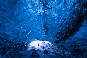 Images Dated 20th July 2017: Man standing at entrance to an ice cave beneath a glacier, Iceland, Europe