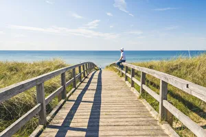 Man standing on a footbridge to WeissenhAA¤user Strand, Ostholstein, Schleswig-Holstein Man standing on a footbridge to WeissenhAA¤user Strand, Ostholstein, Schleswig-Holstein