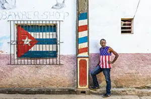 Street Art Prints: A man standing outside a barber shop in La Habana Vieja (Old Town), Havana, Cuba