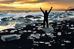 Man stands amongst the icebergs, Glacial lake with icebergs Jokulsarlon, Iceland