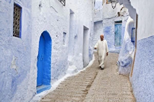 Man in traditional Moroccan clothing walking in the streets of Chefchaouen, Morocco