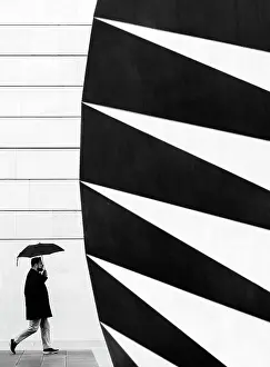Umbrella Prints: Man with umbrella walking past the Angel's Wings air vent in Paternoster Square